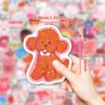 A pile of 100 BestiePal holographic Valentine's Day heart stickers with various romantic messages and patterns, reflecting ra
