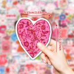 A pile of 100 BestiePal holographic Valentine's Day heart stickers with various romantic messages and patterns, reflecting ra