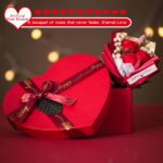 Red heart-shaped gift box open to reveal a 12 oz insulated tumbler, bath bomb, mirror, soap roses, and other spa items.