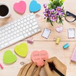 A stack of multicolor OHOME heart sticky notes, showcasing dark blue, light pink, neon green, orange, bright green, and hot p