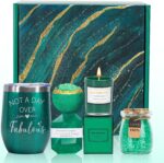 An emerald green spa gift basket featuring a bath bomb, body salt, candle, gem soap, and a stainless steel wine mug.