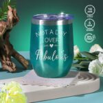 An emerald green spa gift basket featuring a bath bomb, body salt, candle, gem soap, and a stainless steel wine mug.
