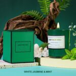 An emerald green spa gift basket featuring a bath bomb, body salt, candle, gem soap, and a stainless steel wine mug.