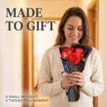A vibrant red artificial rose bouquet featuring three realistic soap flower blooms with green faux silk leaves, arranged in a